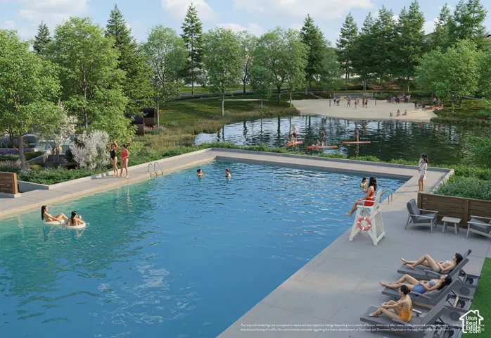 Outdoor swimming pool featuring a concrete deck, adjacent natural pond, and surrounding mature landscaping