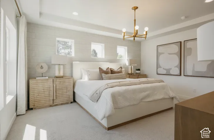 Recessed lighting, tray ceiling, wall-mounted light fixture, three high windows, and textured accent wall