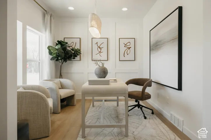 Recessed lighting, wood-finish flooring, and a decorative pendant light