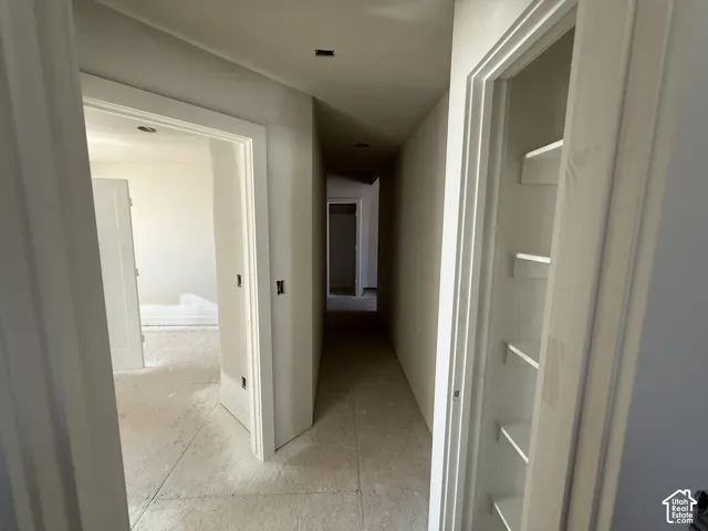 Hallway featuring recessed lighting, a built-in shelving unit, and multiple doorways