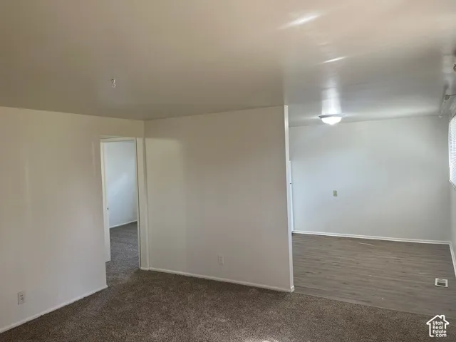 Carpeted area with white walls and a doorway