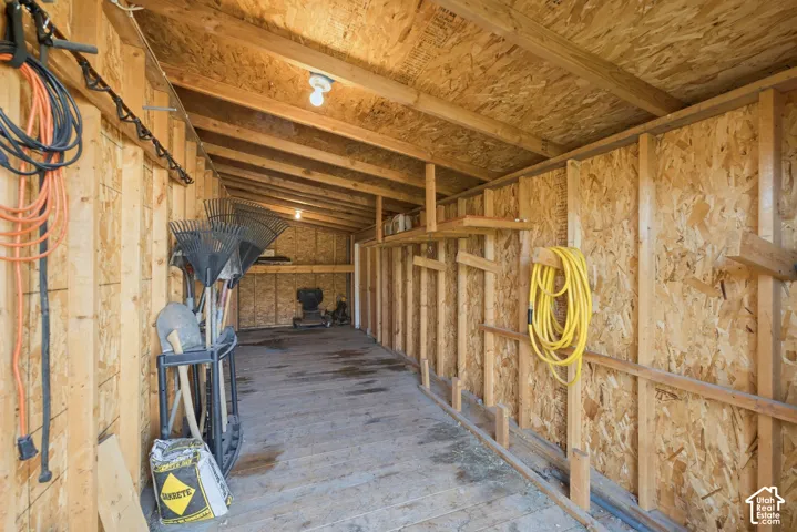 Exposed wood framing with oriented strand board walls and ceiling, concrete flooring, and overhead lighting