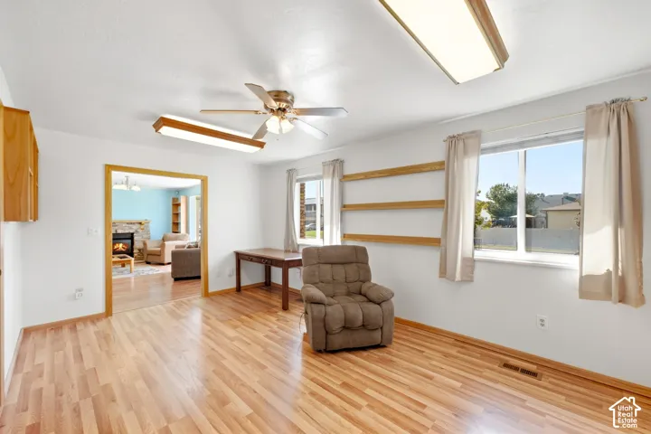 Wood-finish flooring, recessed lighting, ceiling fan, built-in shelving, and light wood cabinetry