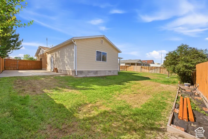 Expansive grassy yard with wood fencing and a concrete patio
