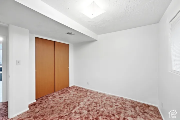 Recessed lighting, wood-finish sliding closet doors, and white interior walls