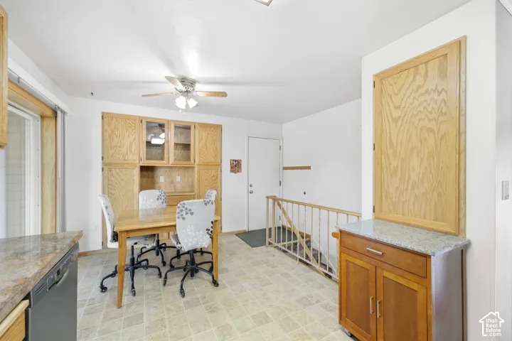 Built-in wood-finish cabinetry with glass accents, ceiling fan with integrated lighting, wood-finish railing, and light-toned floor tile