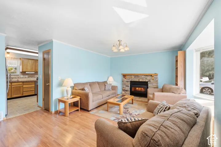 Living area with wood-finish flooring, a stone-surround fireplace, and a bay window