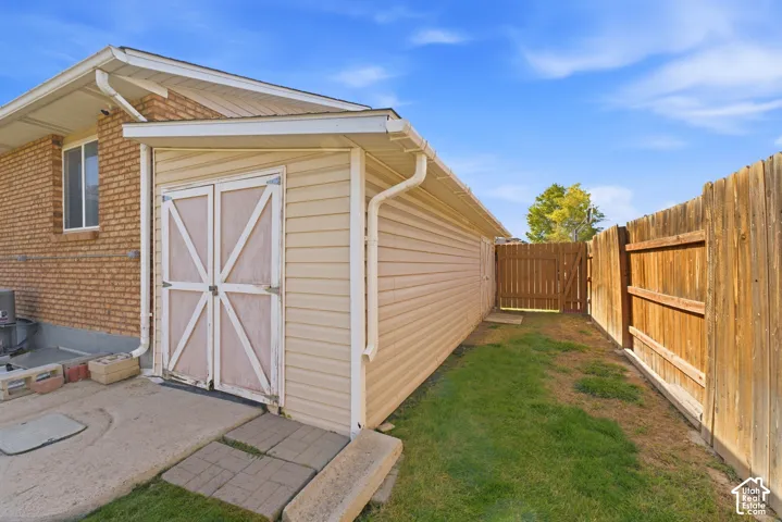 Detached shed with double barn doors, wood-paneled siding, and a gabled roof