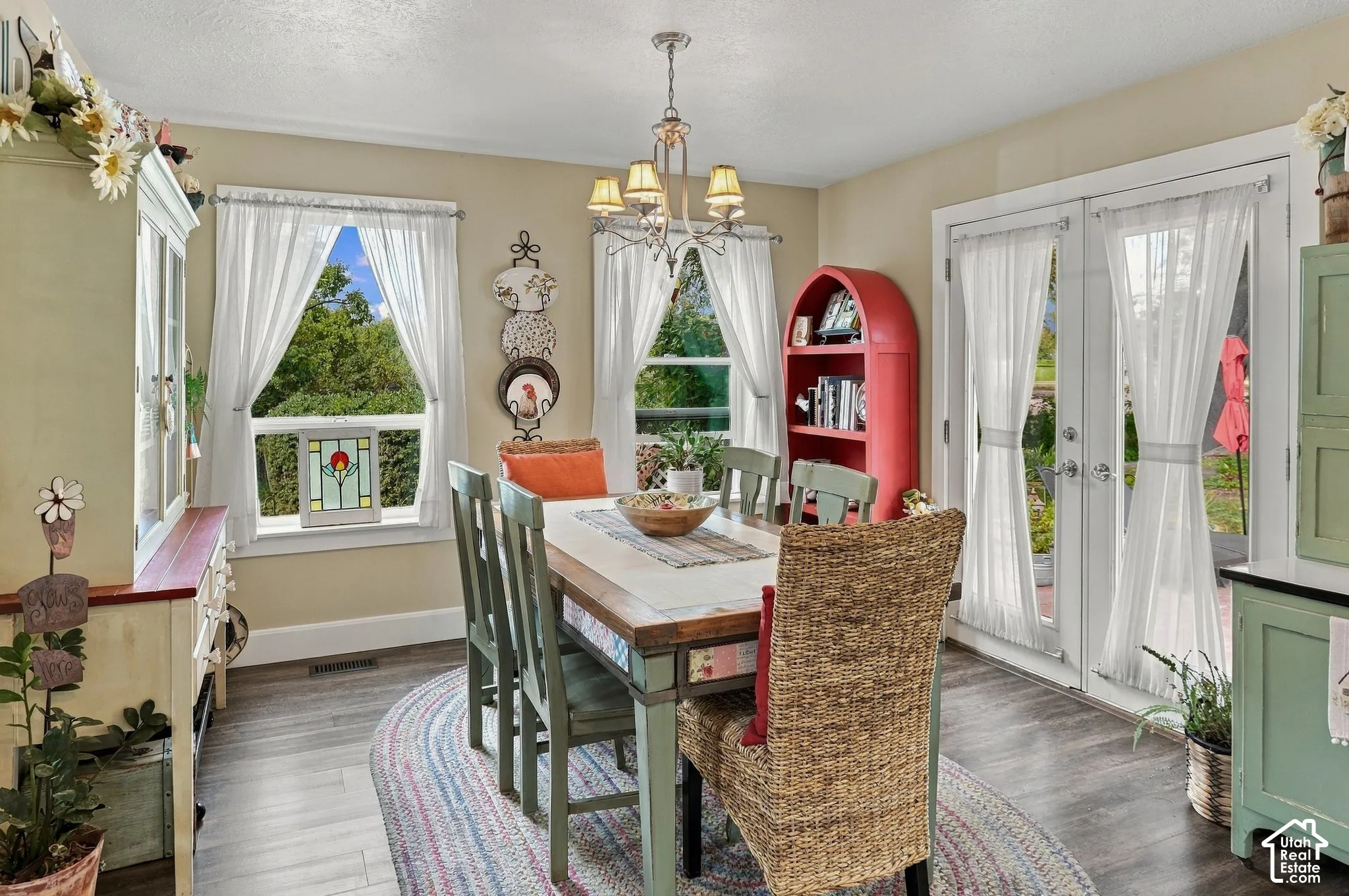 Dining area featuring wood-finish flooring, two window openings, and a double patio door
