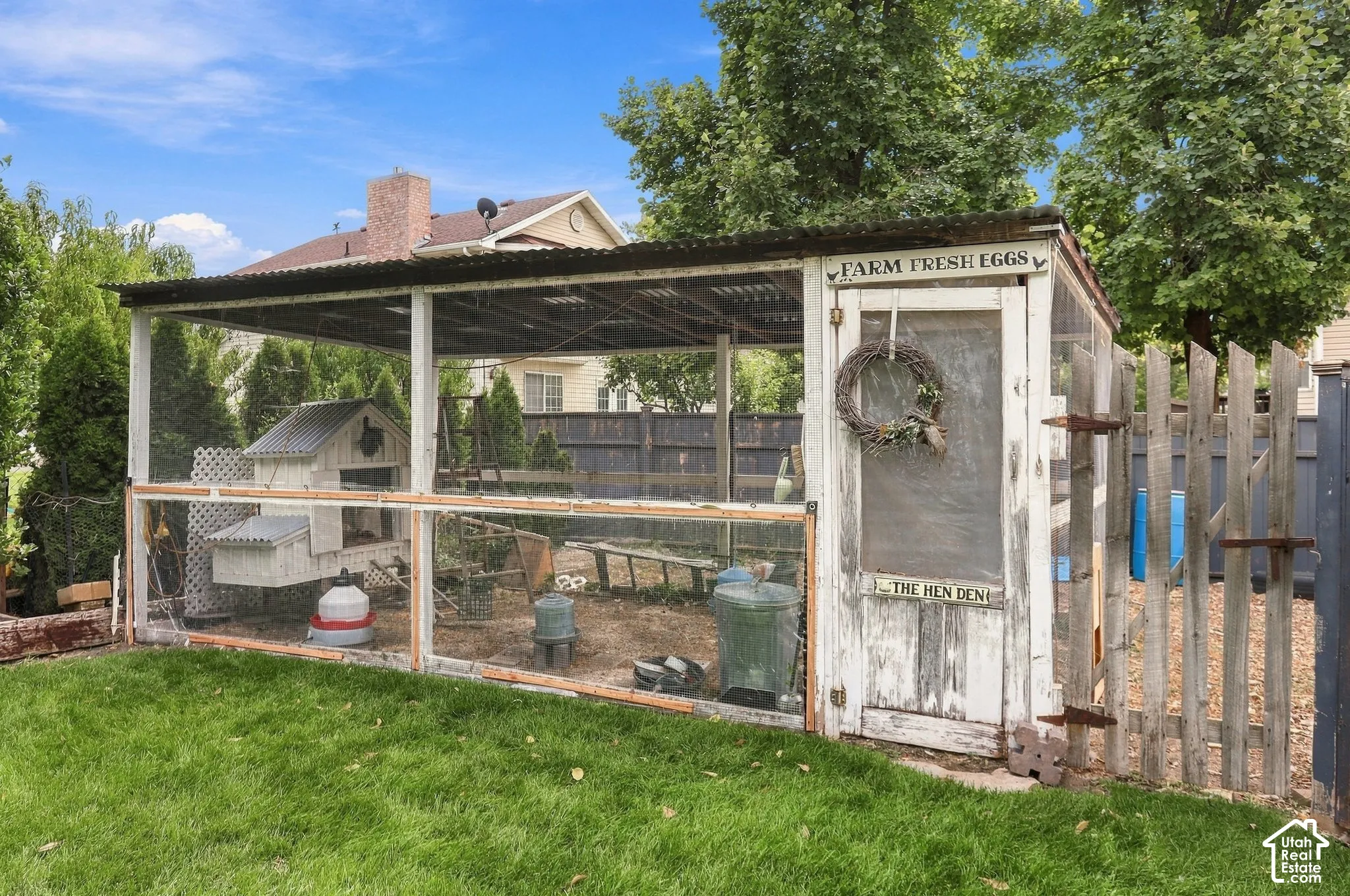 Enclosed outdoor structure with metal roof, wood-paneled walls, and a separate fenced area