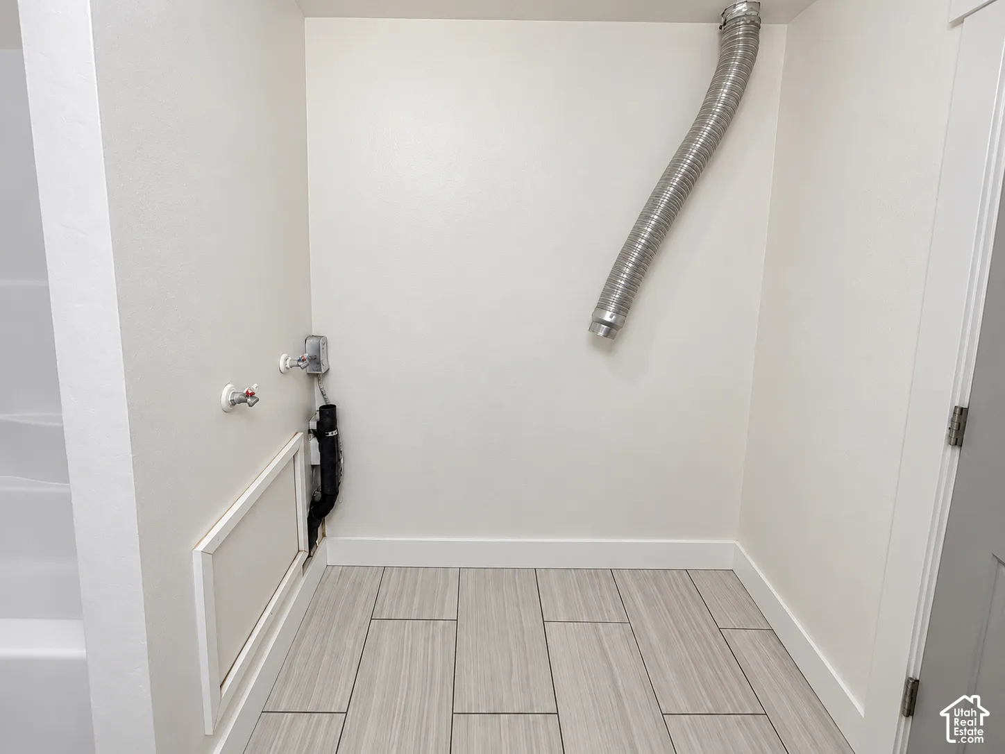 Laundry alcove featuring tile flooring and dedicated dryer venting
