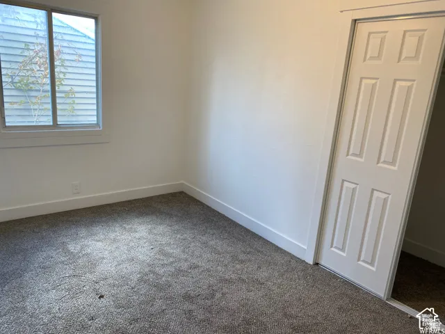 Light-colored carpeting, white walls, and a closet with a bifold door
