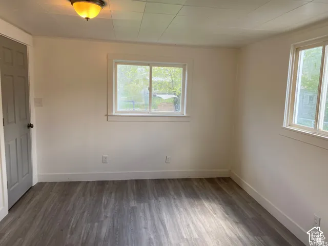 Wood-finish flooring, white walls, and multiple windows