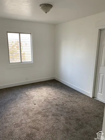 Neutral-toned carpeting, white walls, white trim, and a semi-flush mount ceiling light