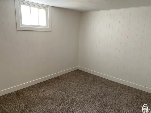 Light-colored paneled walls with a contrasting carpeted floor and a single window