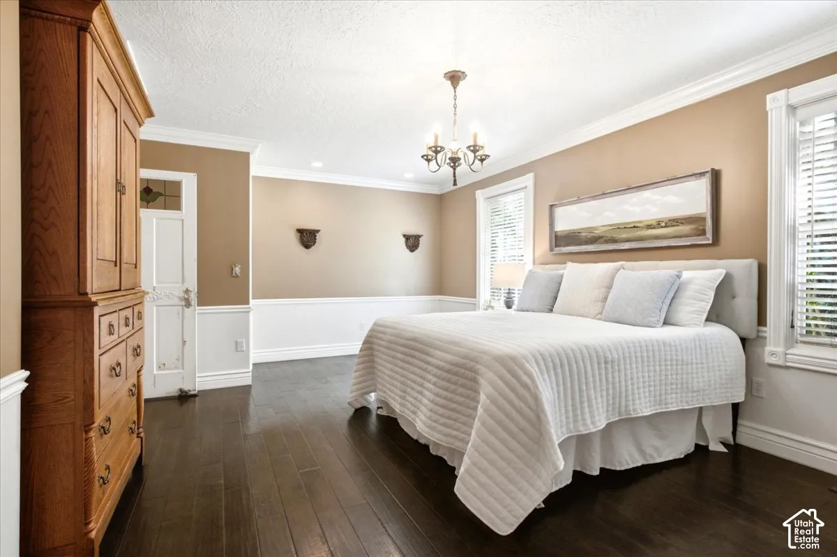 Dark wood-finish flooring with crown molding and wainscoting