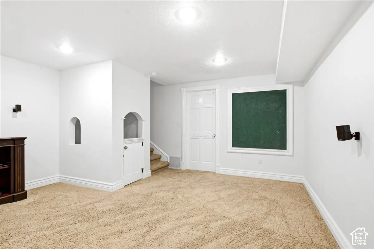Recessed lighting, carpeted flooring, built-in wall niche, interior door, and staircase access
