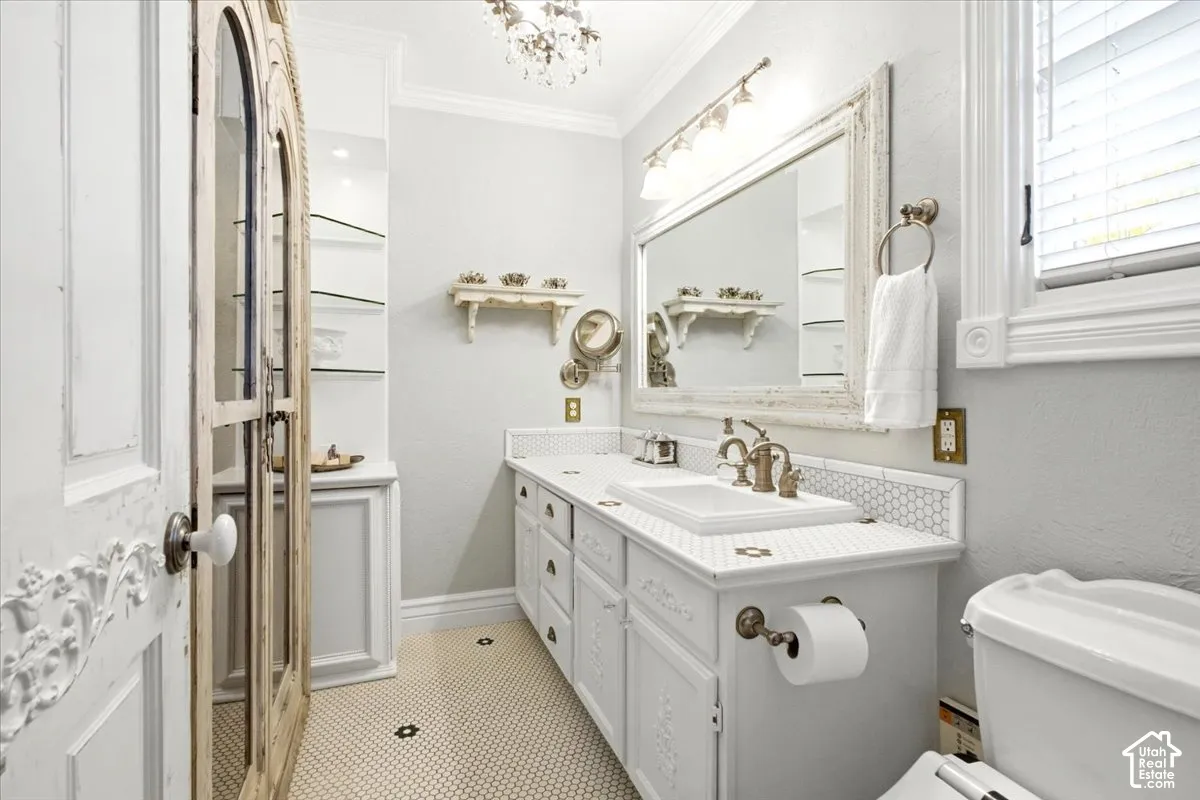 Vanity with an integrated sink, hexagon tile countertop, and decorative bronze-finish fixtures