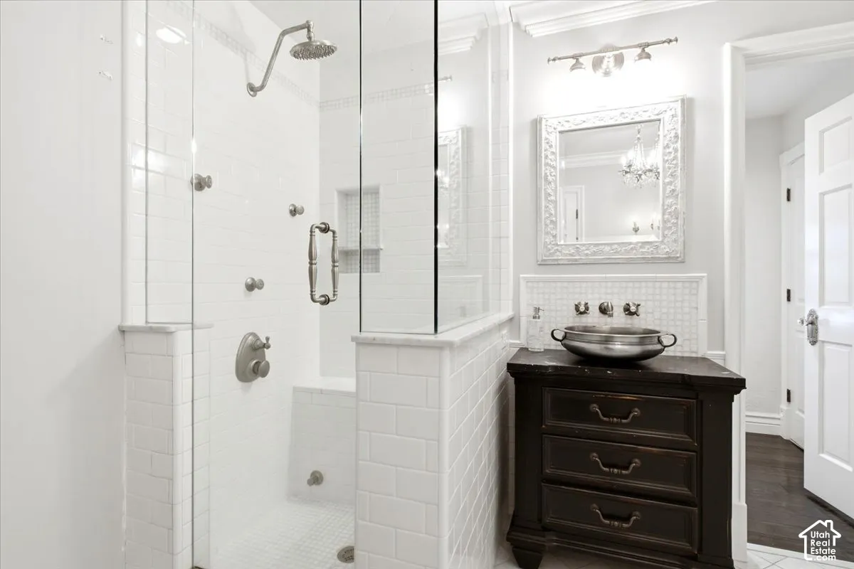 Glass-enclosed shower with multiple body sprayers, rain showerhead, and built-in bench