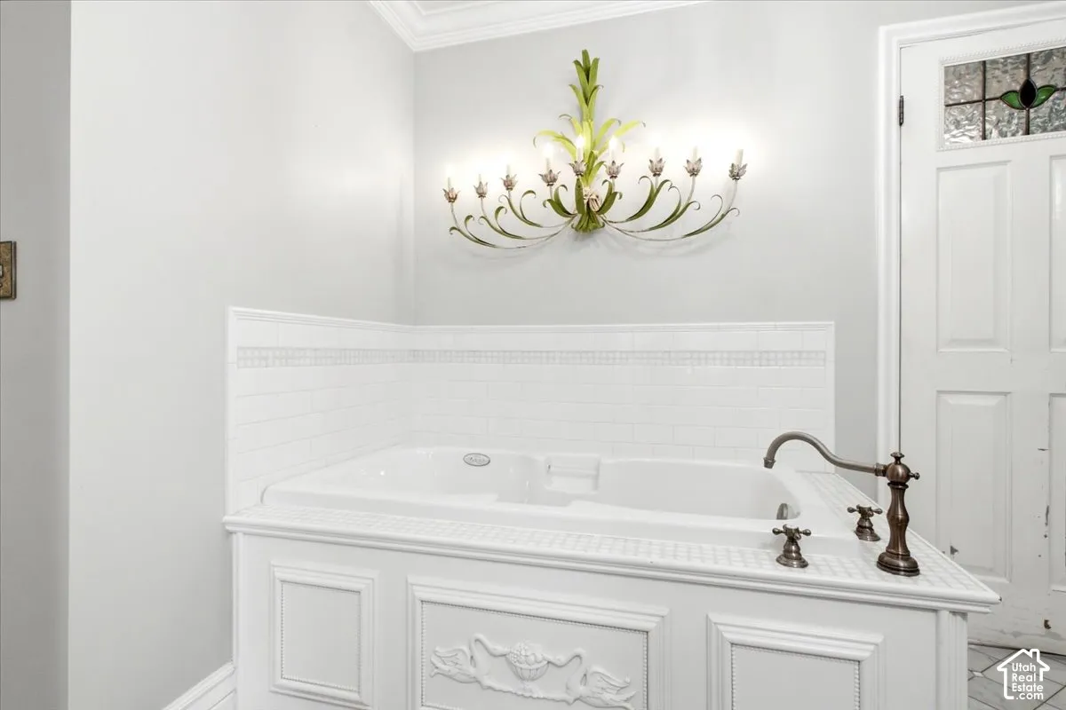 Built-in soaking tub with decorative paneling and an antique bronze-finish faucet