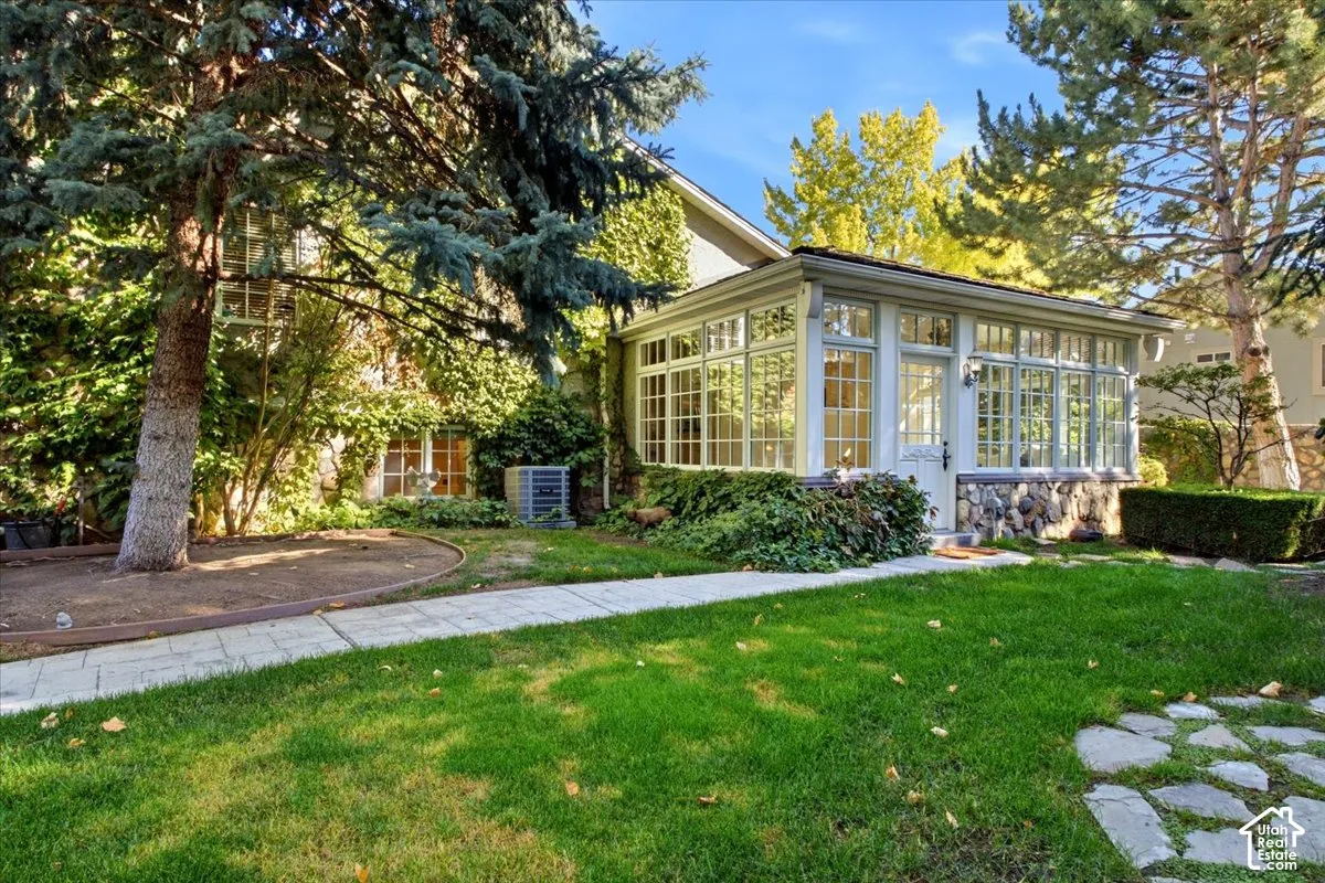 Sunroom addition with multiple windows, stone foundation, and a central entry door
