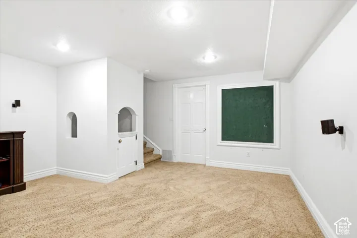 Recessed lighting, carpeted flooring, built-in wall niche, interior door, and staircase access
