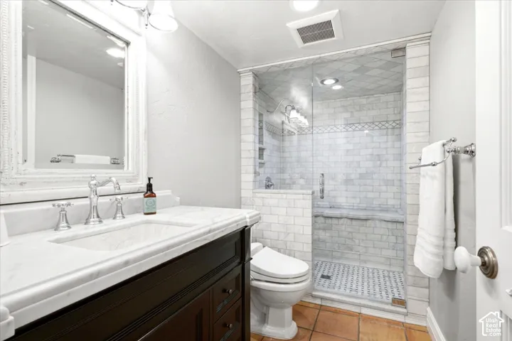 Vanity with white countertop and integrated sink, chrome faucet, framed mirror, and dark wood-finish cabinetry
