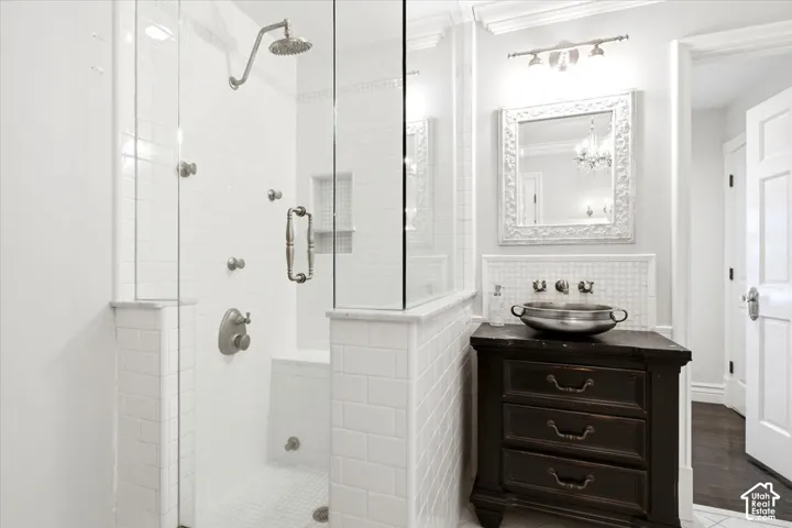 Glass-enclosed shower with multiple body sprayers, rain showerhead, and built-in bench