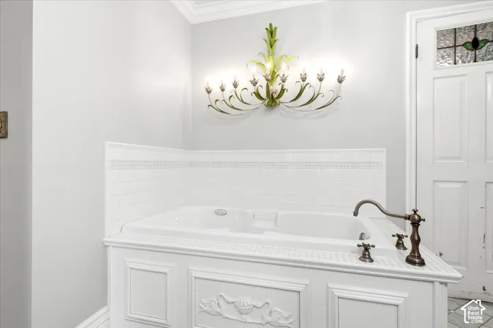 Built-in soaking tub with decorative paneling and an antique bronze-finish faucet