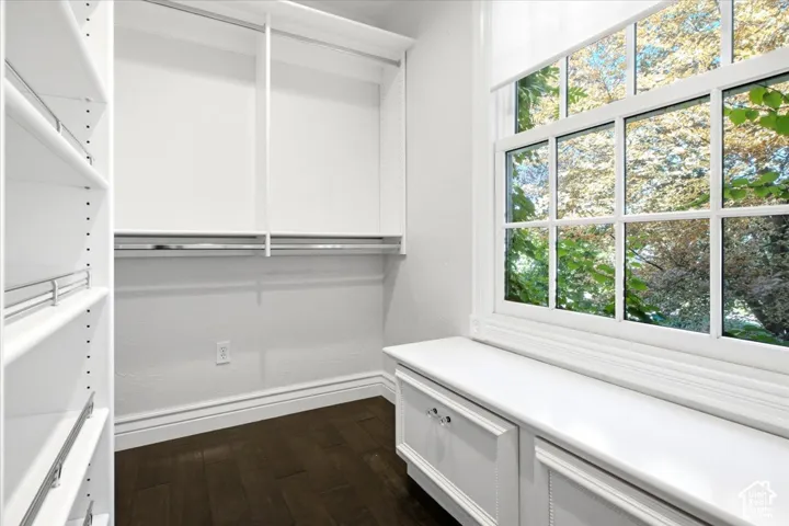 Custom closet system featuring shelving, hanging rods, and a built-in storage bench