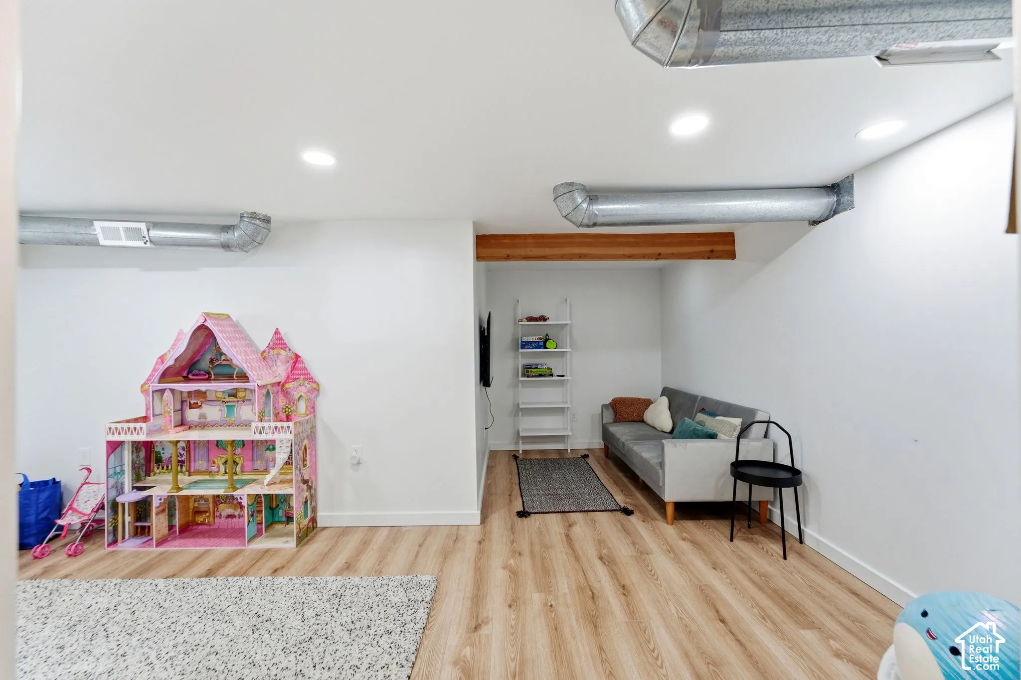 Recessed lighting, exposed ductwork, wood-finish flooring, and a structural wood beam