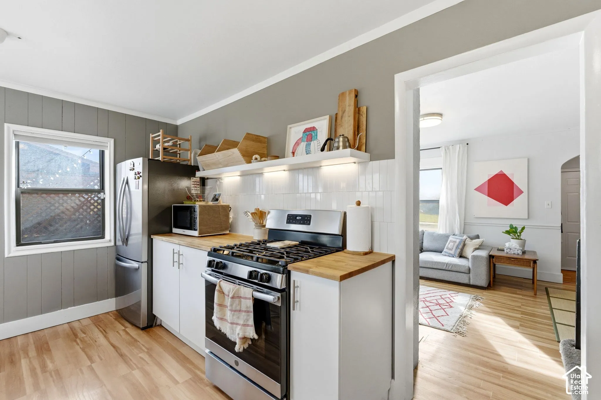 Kitchen with wood-finish flooring, white cabinetry, and wood countertops