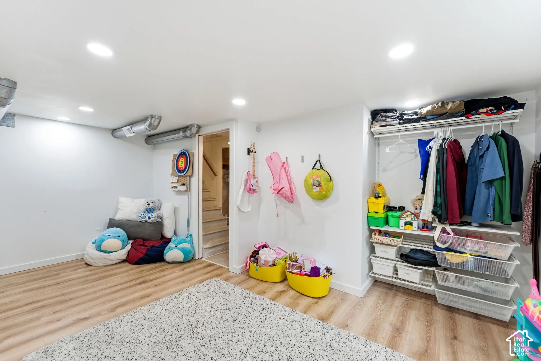 Recessed lighting, wood-finish flooring, exposed ductwork, built-in open closet system, and staircase access