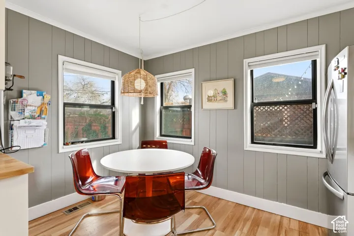Wood-finish flooring with grey vertical paneling and multiple windows