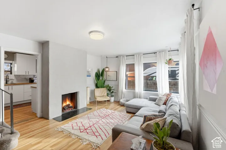 Hardwood flooring, a built-in fireplace with a dark hearth, multiple windows, and recessed lighting
