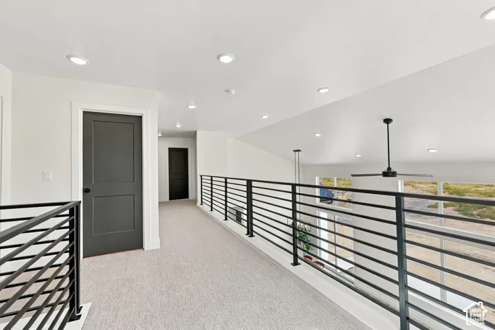 Upper-level hallway with contemporary black railing and light-colored carpet