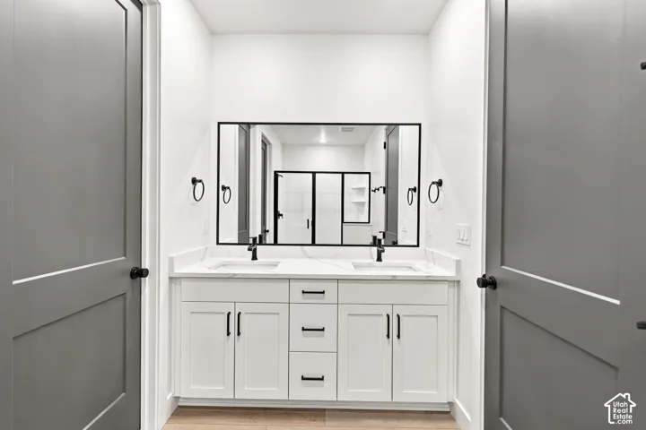 Dual vanity with undermount sinks, stone countertops, and matte black fixtures