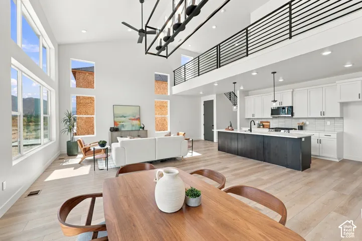 Vaulted ceilings with an open-concept living area, wood-finish flooring, and a kitchen island with pendant lighting