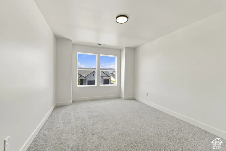 Recessed windows with multiple panes, neutral carpeting, white wall finishes, and a flush-mount ceiling light fixture
