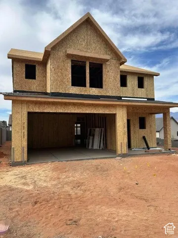 Two-story house under construction featuring a prominent front-facing gable, a two-car garage with a concrete pad, and a covered front entry