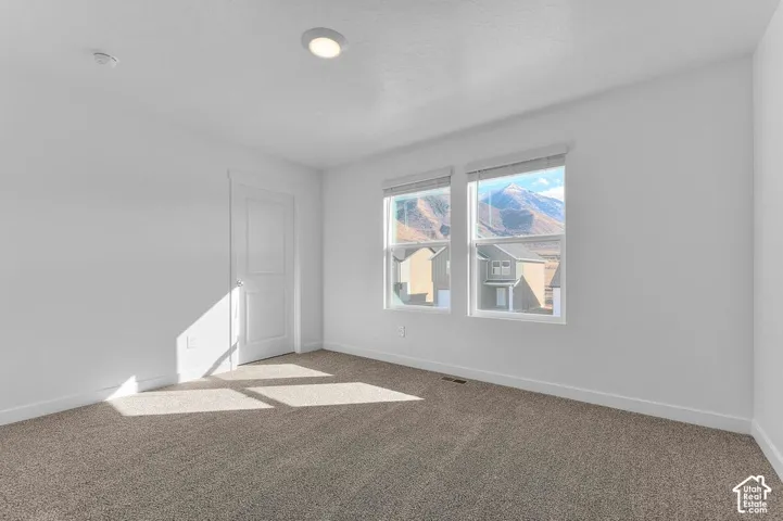 Recessed ceiling lighting, two windows, mountain backdrop, and carpet flooring