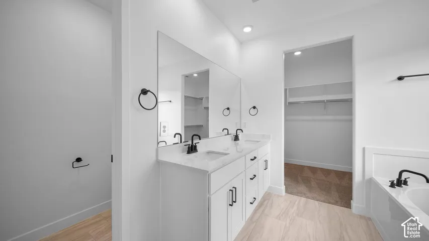Dual vanity featuring white cabinetry, light-toned countertops, and matte black fixtures