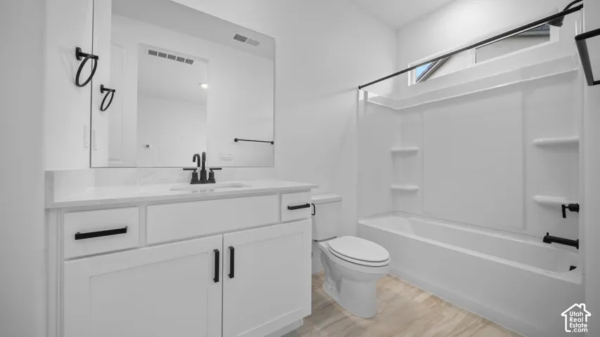 Contemporary vanity with white cabinetry, black hardware, an integrated sink, and a large wall-mounted mirror