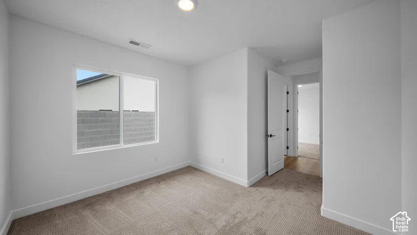 Neutral tone carpet flooring with white baseboards