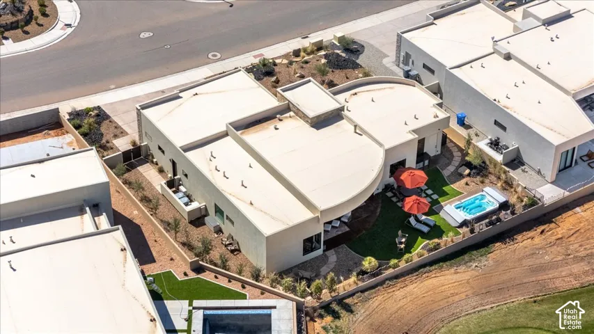 Contemporary architecture featuring a private rear yard with artificial turf, a built-in spa, and xeriscaping