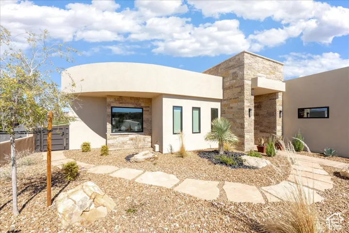 Contemporary exterior with stone facade accents and stucco finishes