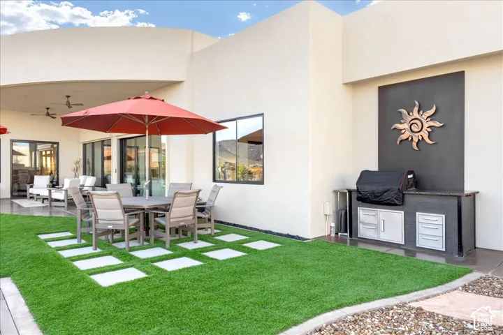 Expansive patio with built-in outdoor kitchen, recessed ceiling fans, and sliding glass doors