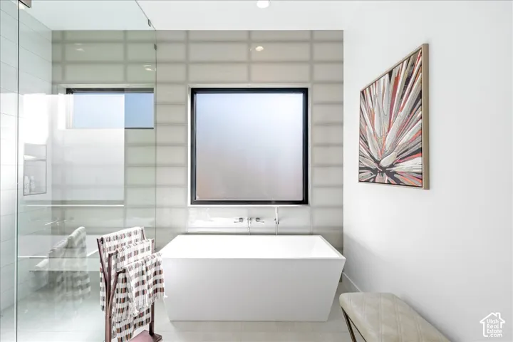Freestanding soaking tub with wall-mounted fixtures