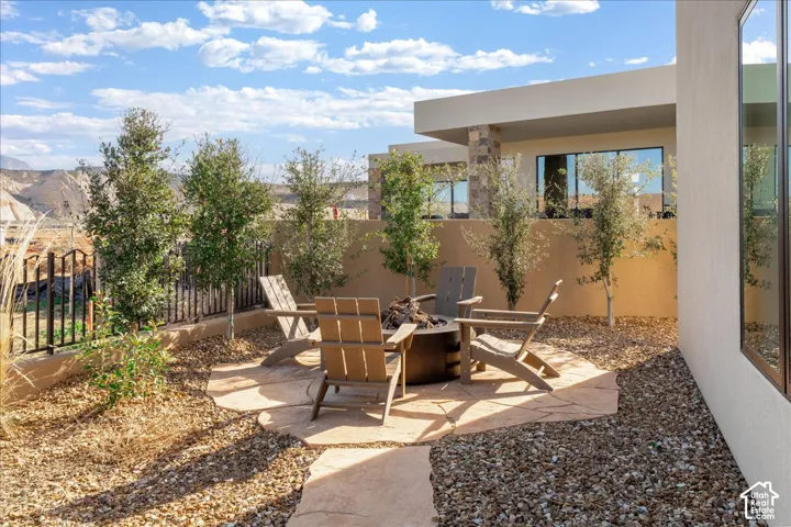 Outdoor patio featuring a flagstone-style surface, surrounded by gravel and mature landscaping