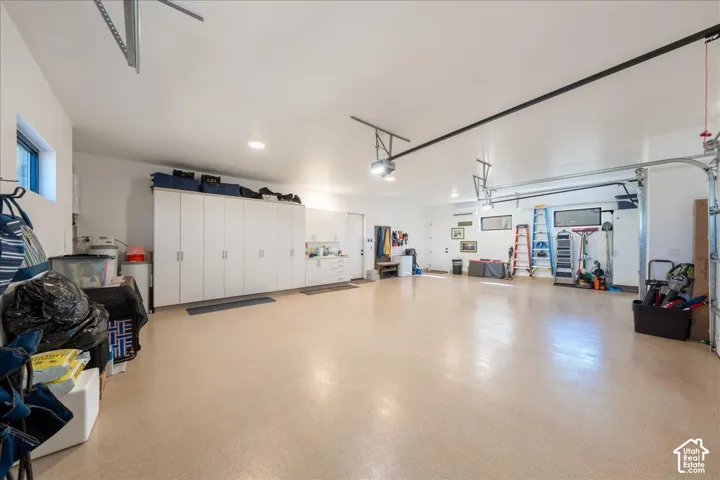 Spacious garage with light-colored flooring, recessed lighting, and extensive built-in white cabinetry